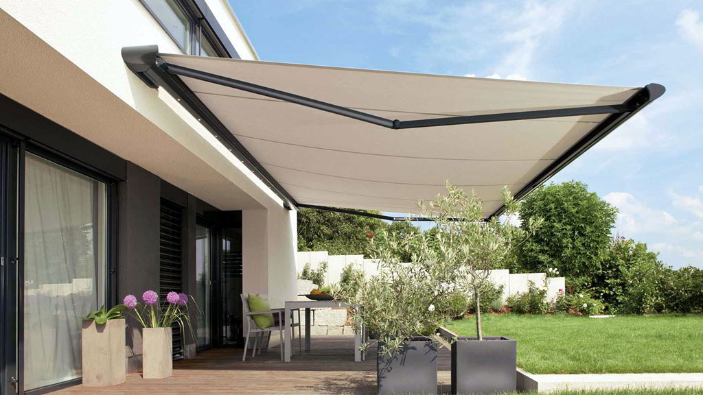 Hombre midiendo ancho de terraza con metro extensible para instalar toldo